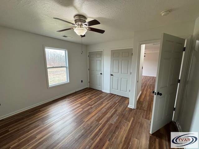 5380 Sulphur Creek Rd, Big Sandy, TN 38221 - unfurnished bedroom with dark wood-type flooring, visible vents, a textured ceiling, and baseboards