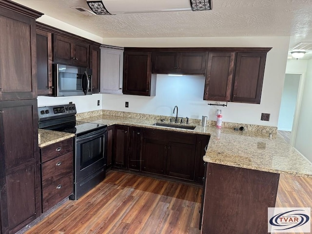 5380 Sulphur Creek Rd, Big Sandy, TN 38221 - kitchen with dark brown cabinetry, a peninsula, dark wood-style flooring, a sink, and electric range oven
