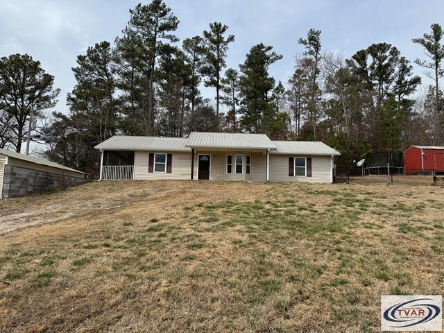 5380 Sulphur Creek Rd, Big Sandy, TN 38221 - ranch-style home with a front lawn, fence, and metal roof