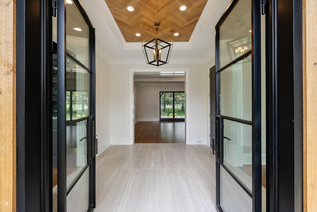 521 Mansion Dr, Brentwood, TN 37027 - hallway featuring baseboards, a notable chandelier, ornamental molding, a tray ceiling, and french doors