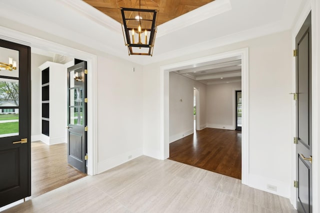 521 Mansion Dr, Brentwood, TN 37027 - spare room with baseboards, a raised ceiling, a notable chandelier, ornamental molding, and wood finished floors