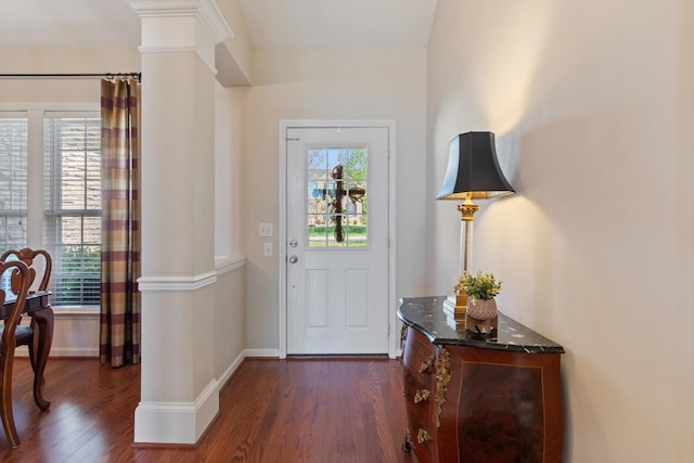 entrance foyer featuring baseboards, decorative columns, and dark wood-style floors