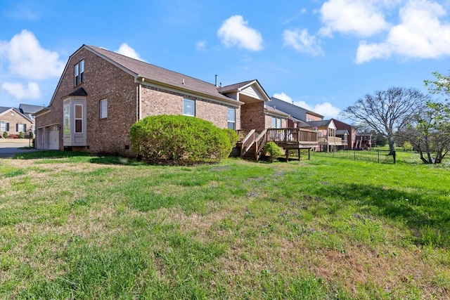 exterior space featuring brick siding, a deck, a lawn, and crawl space