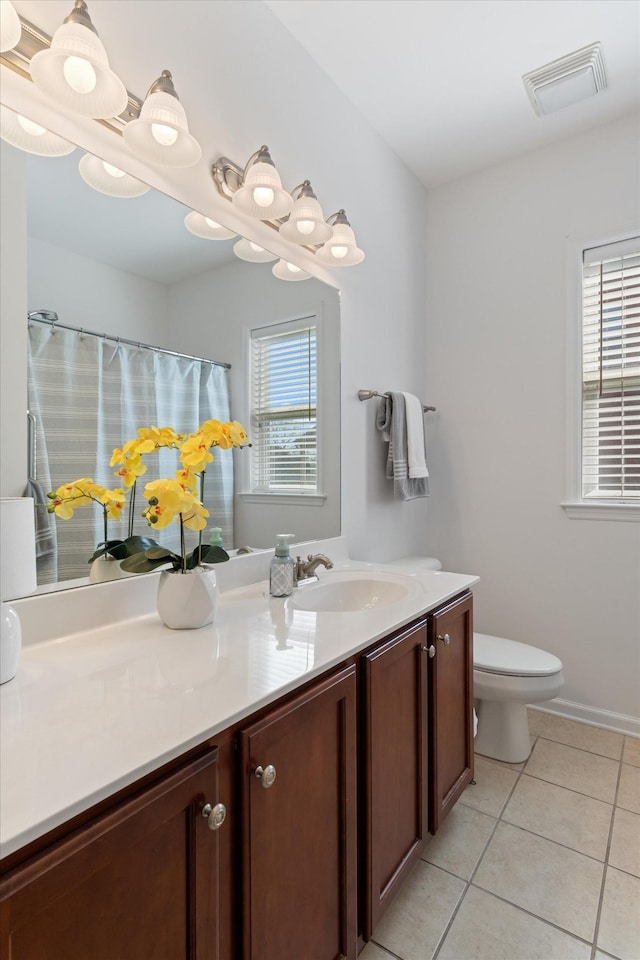 bathroom featuring plenty of natural light, vanity, visible vents, and tile patterned flooring