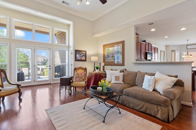 living room with recessed lighting, dark wood-style floors, crown molding, visible vents, and ceiling fan with notable chandelier