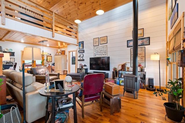 1720 Bratton Ln, Williamsport, TN 38487 - living room featuring a wood stove, a towering ceiling, wood ceiling, wood finished floors, and wooden walls