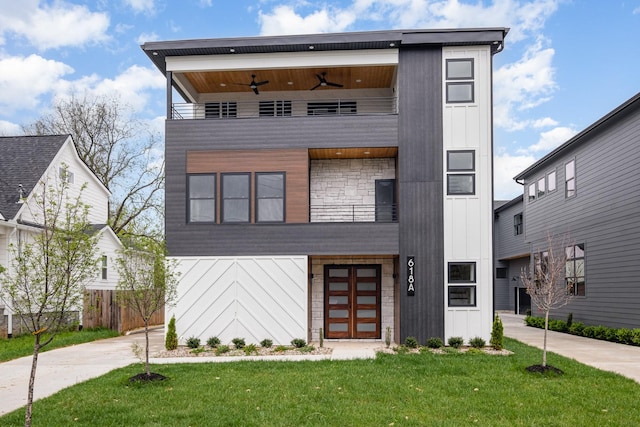 contemporary house with board and batten siding, ceiling fan, a front yard, and a balcony