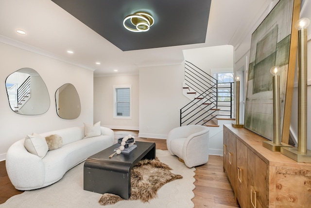 living room featuring baseboards, ornamental molding, light wood-style floors, recessed lighting, and stairs