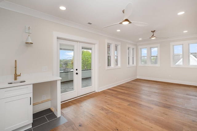 interior space featuring a wealth of natural light, french doors, a sink, and crown molding