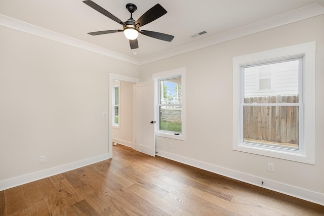 spare room with visible vents, baseboards, a ceiling fan, crown molding, and wood finished floors