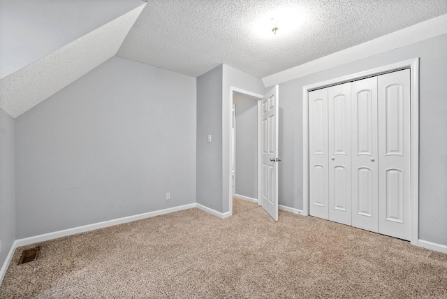 additional living space featuring visible vents, light colored carpet, baseboards, and lofted ceiling