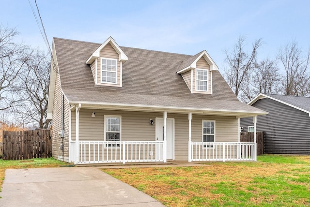 view of front facade featuring a porch, roof with shingles, a front yard, and fence