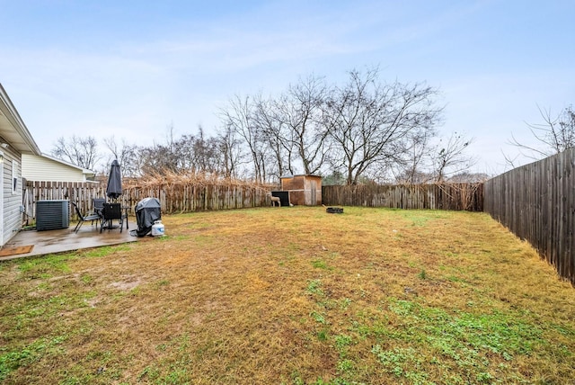 view of yard featuring cooling unit, a fenced backyard, an outdoor structure, a patio, and a storage unit
