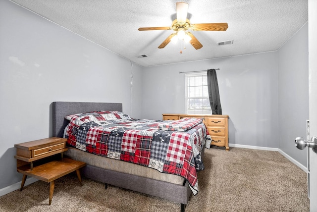 carpeted bedroom featuring visible vents, baseboards, a ceiling fan, and a textured ceiling