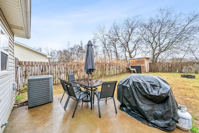 view of patio featuring central AC unit, a fenced backyard, a grill, and outdoor dining area