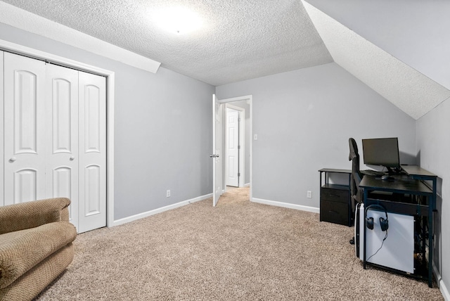 office with baseboards, light colored carpet, vaulted ceiling, and a textured ceiling
