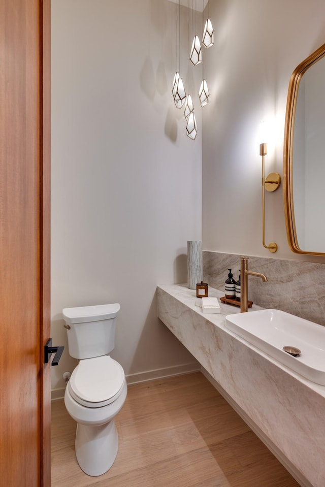 2108 12th Ave S, Nashville, TN 37204 - bathroom featuring a sink, toilet, wood finished floors, and baseboards