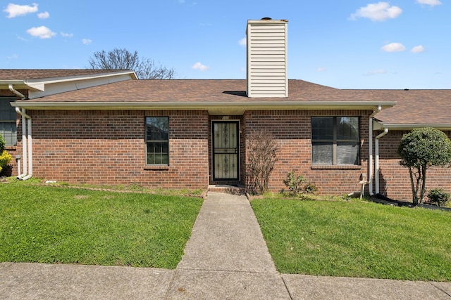 107 Heritage Trace Dr, Madison, TN 37115 - view of front of house featuring roof with shingles, brick siding, a chimney, and a front lawn