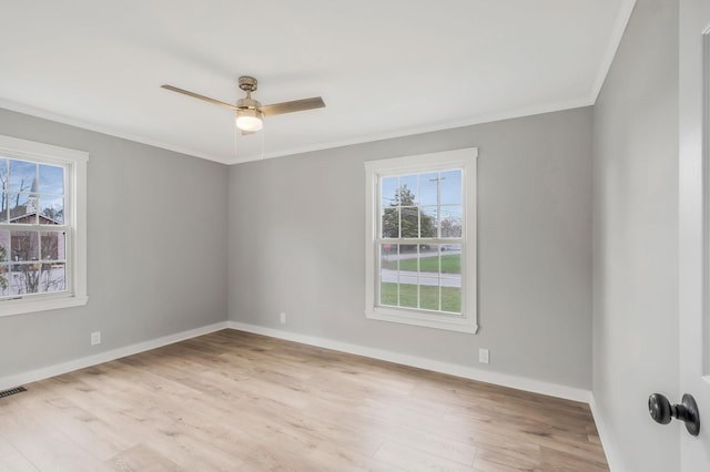 empty room with crown molding, wood finished floors, ceiling fan, and a healthy amount of sunlight