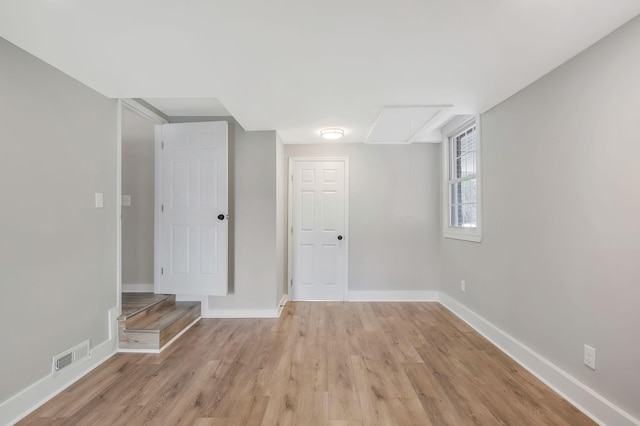 below grade area featuring light wood finished floors, baseboards, and visible vents
