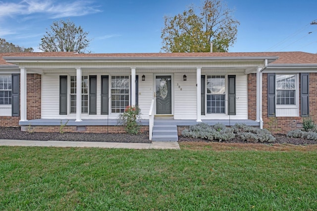 single story home featuring brick siding, a porch, and a front yard