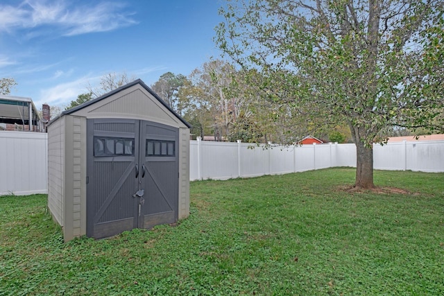 view of yard with a fenced backyard, an outdoor structure, and a storage shed