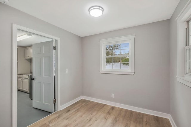 unfurnished room featuring baseboards and light wood-style floors