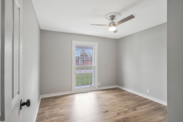 spare room featuring ceiling fan, baseboards, wood finished floors, and visible vents