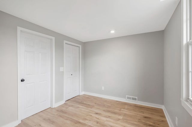 unfurnished bedroom featuring baseboards, light wood-style floors, visible vents, and recessed lighting