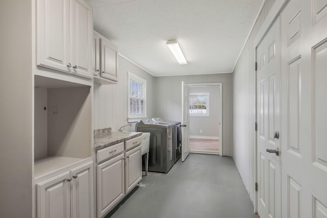 washroom featuring washer and clothes dryer, ornamental molding, and cabinet space