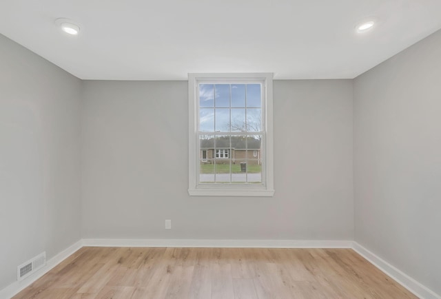 empty room featuring recessed lighting, wood finished floors, visible vents, and baseboards
