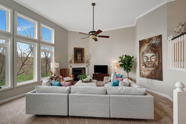 living area with a high ceiling, baseboards, ornamental molding, and carpet