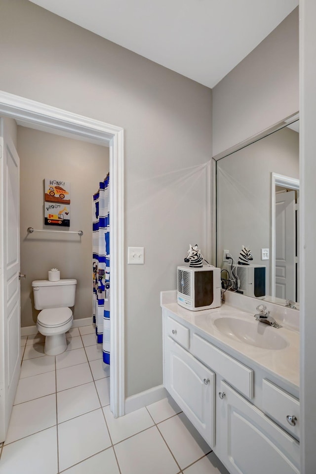 bathroom featuring toilet, tile patterned floors, vanity, and baseboards