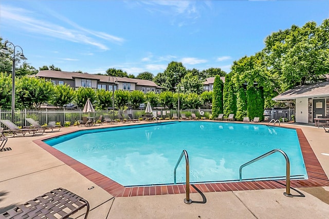 community pool featuring a patio and fence