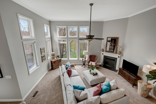 carpeted living room with crown molding, ceiling fan, a fireplace with flush hearth, visible vents, and baseboards