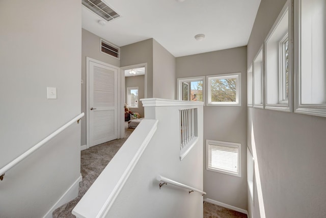 stairs with visible vents, baseboards, and carpet floors