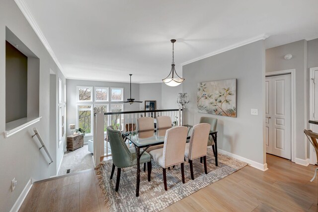 dining space with wood finished floors, ornamental molding, baseboards, and a ceiling fan
