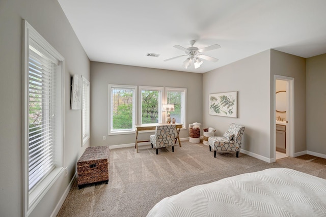 carpeted bedroom with ceiling fan, ensuite bathroom, baseboards, and visible vents
