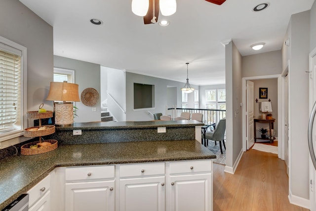 kitchen featuring light wood-style floors, ceiling fan, a peninsula, white cabinetry, and decorative light fixtures