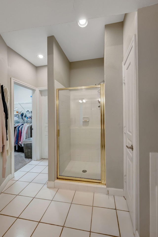 bathroom with a shower stall, tile patterned flooring, a walk in closet, and recessed lighting
