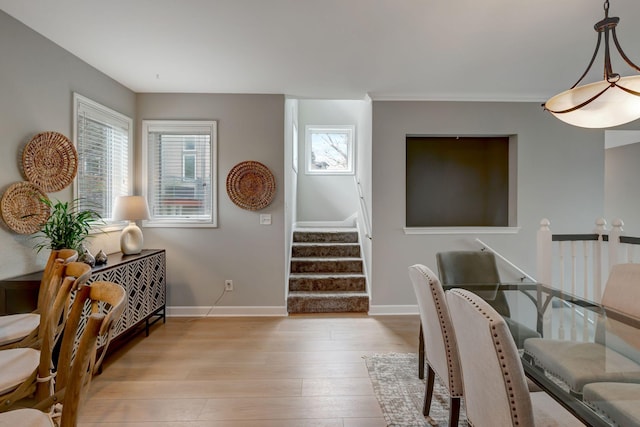 interior space featuring wood finished floors, baseboards, and stairs