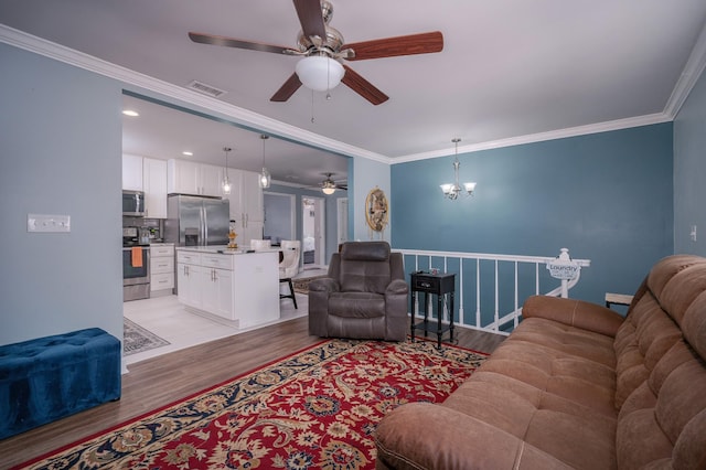 living area with ornamental molding, visible vents, light wood-type flooring, and ceiling fan with notable chandelier