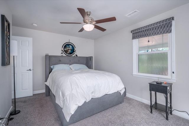 carpeted bedroom with baseboards, a ceiling fan, and visible vents