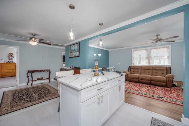 kitchen with open floor plan, white cabinetry, light stone countertops, decorative light fixtures, and ceiling fan