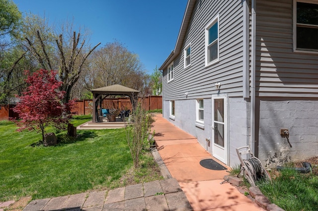 view of home's exterior with a patio, a gazebo, fence, and a lawn