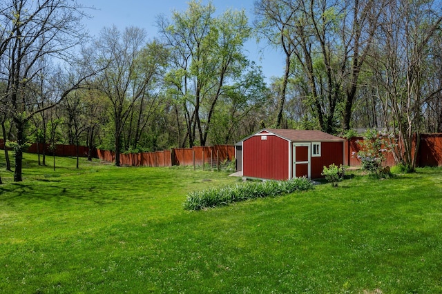 view of yard featuring an outbuilding, a storage unit, and fence private yard