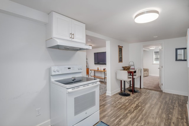 kitchen with baseboards, white cabinets, under cabinet range hood, white electric range, and wood finished floors
