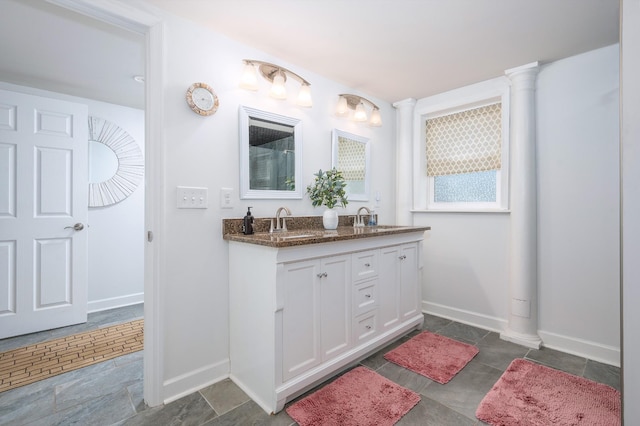 bathroom with double vanity, baseboards, and a sink