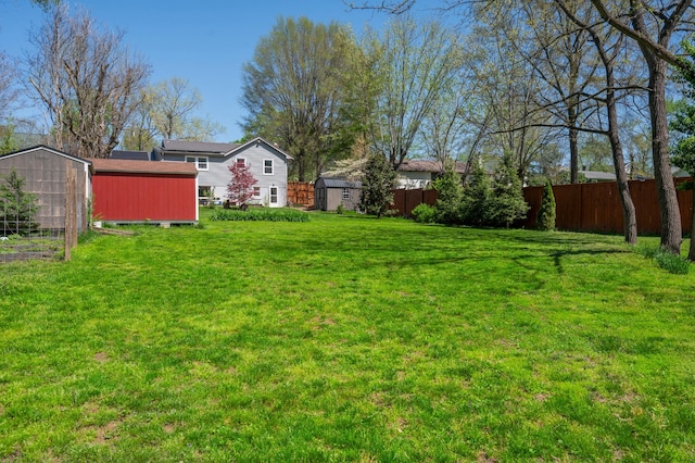 view of yard with a storage shed, fence, and an outdoor structure
