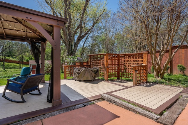 wooden terrace featuring a fenced backyard and a gazebo